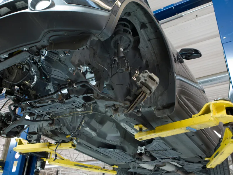 車をリフトアップして足回りやエンジンの異音を点検する様子